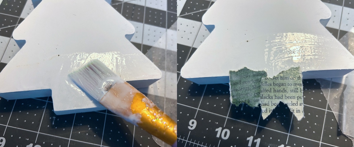 adding dark green book page pieces to the bottom of the wood tree with Mod Podge