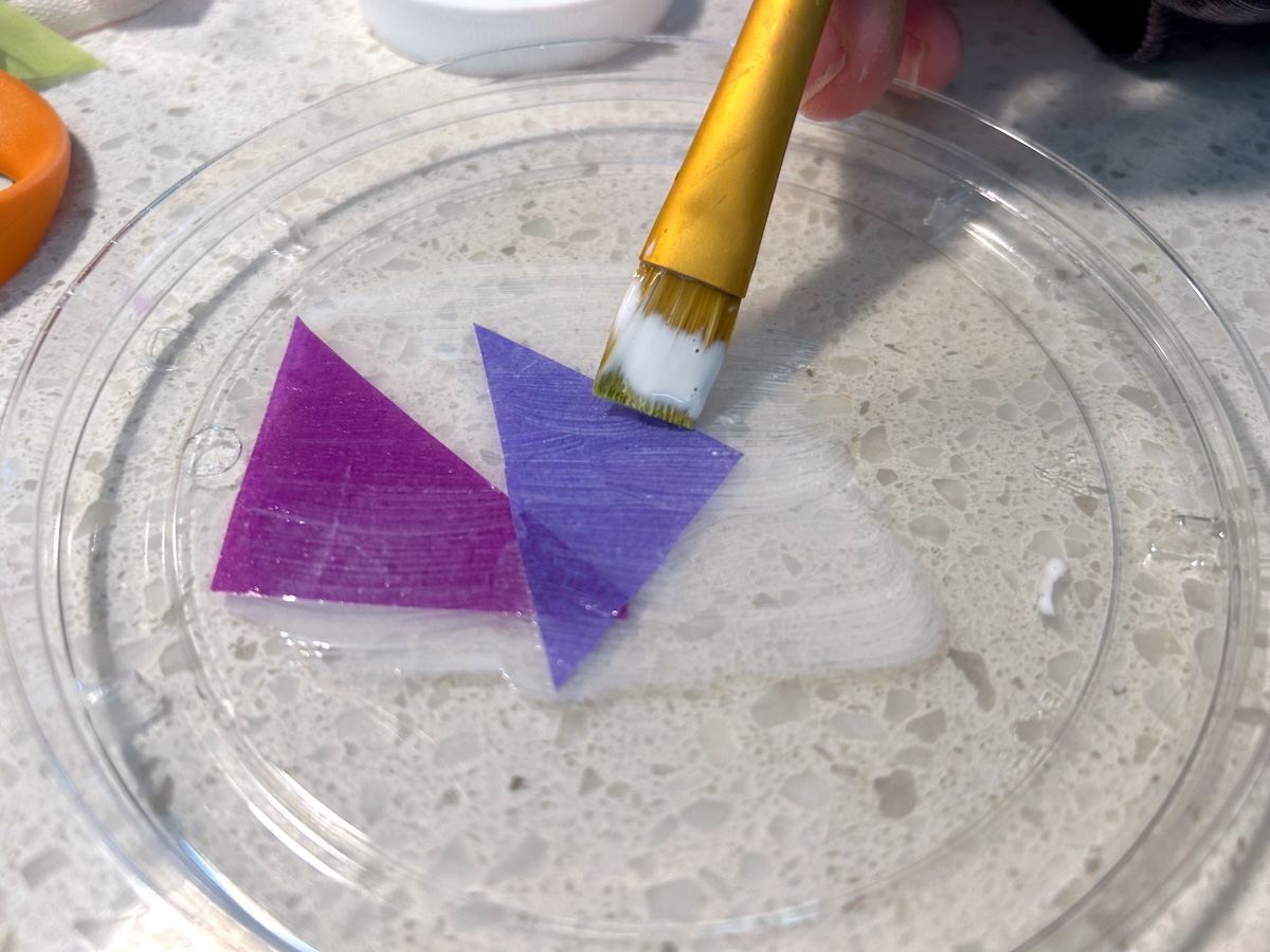 brushing Mod Podge over the top of tissue paper