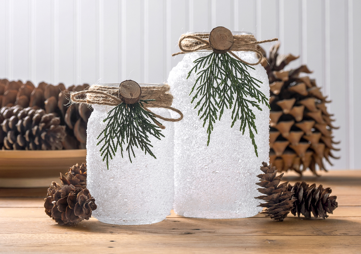Christmas luminaries sitting in front of pinecones