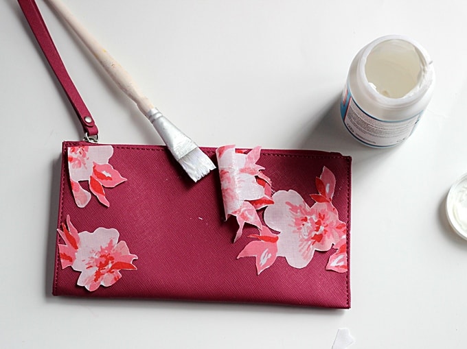 Adding Mod Podge to the back of the fabric on the front of the clutch