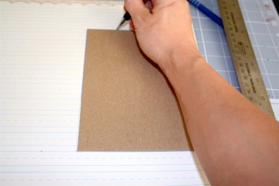 Tracing the cardboard on scrapbook paper with a pen