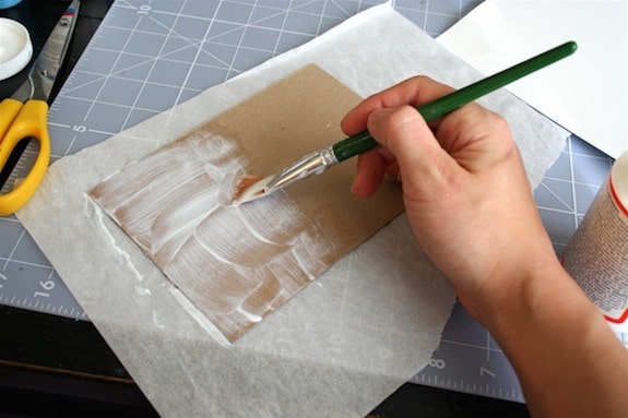 Applying Mod Podge to the thin cardboard with a brush