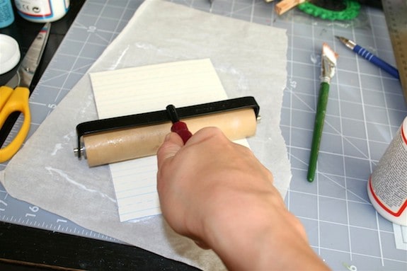 Smoothing the scrapbook paper onto the thin cardboard