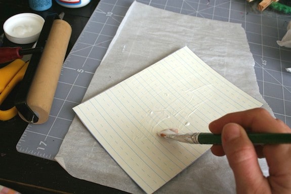Coating the top of the scrapbook paper with Mod Podge