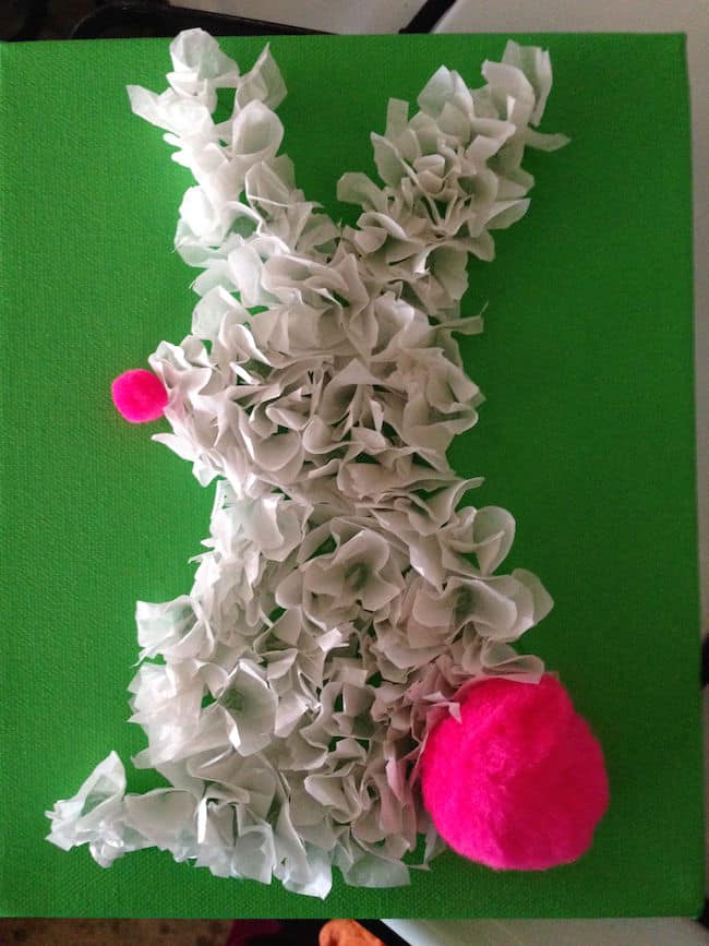 Adding pink pom poms to the bunny on canvas