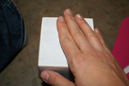 Hand smoothing an image down on a block
