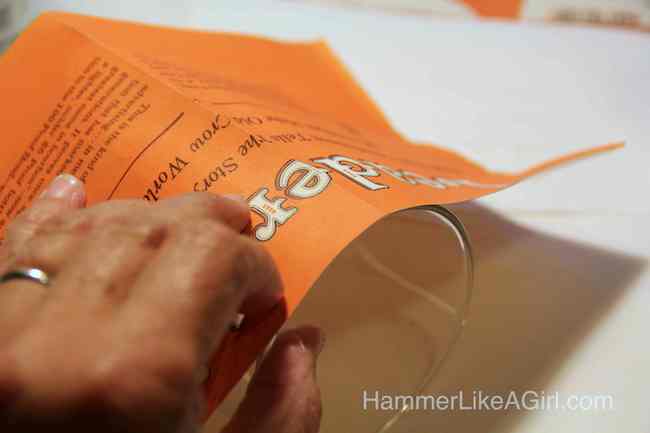 Hand wrapping a magazine page around glass