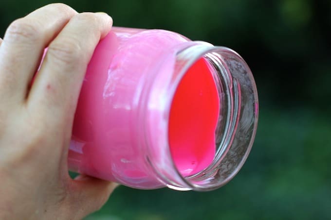 Swirling Mod Podge and food coloring in a jar