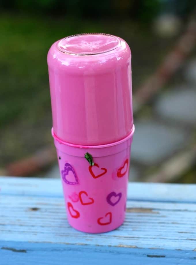 Mason jar placed upside down in a cup to allow the excess Mod Podge to drain out