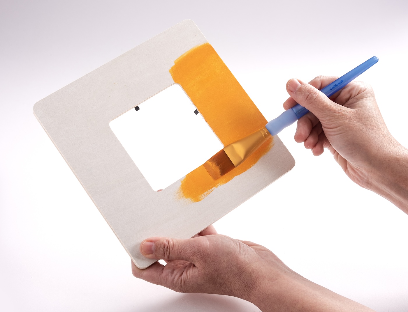 Painting a wood frame with orange craft paint