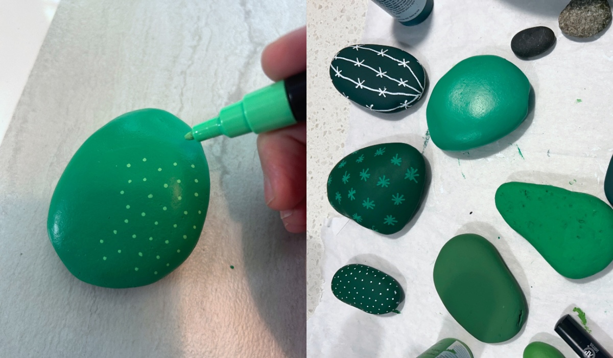 painting on green rocks with a paint pen