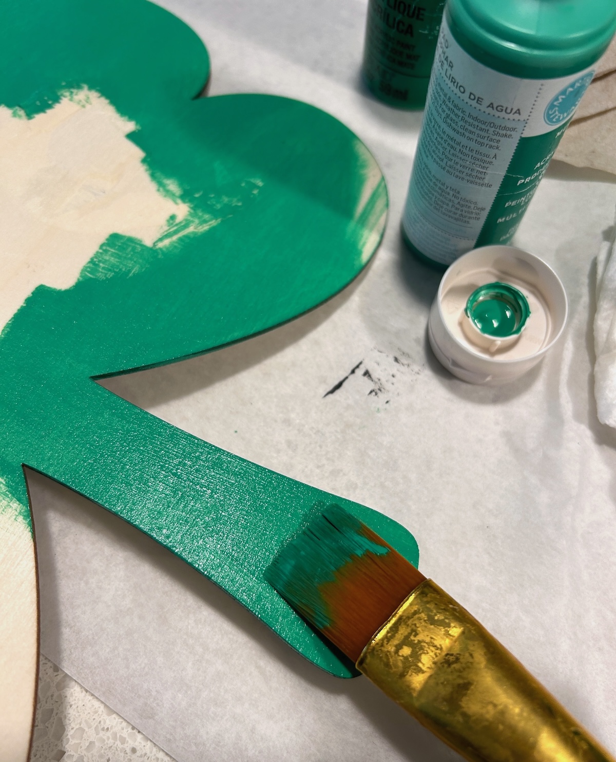 painting the wood shamrock with green paint