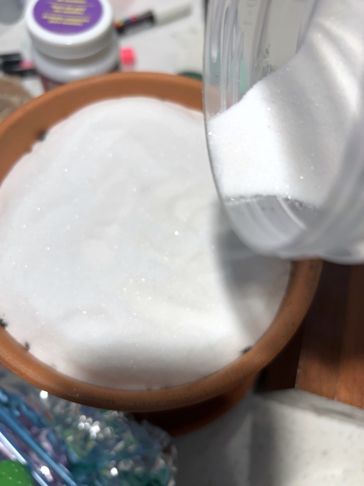 pouring white sand into the terra cotta pot