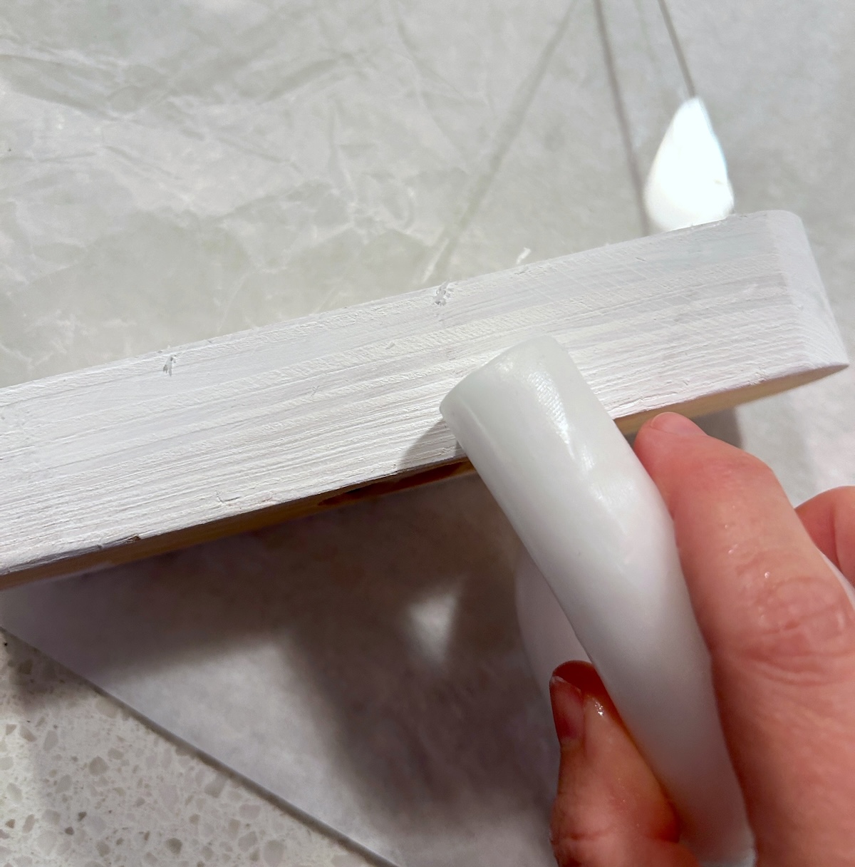 Rubbing a wax candle on top of the white paint