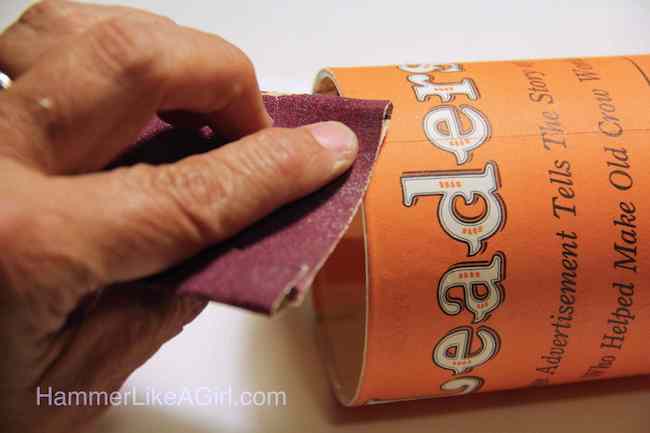 Sanding the edges of the paper on the glass with Mod Podge
