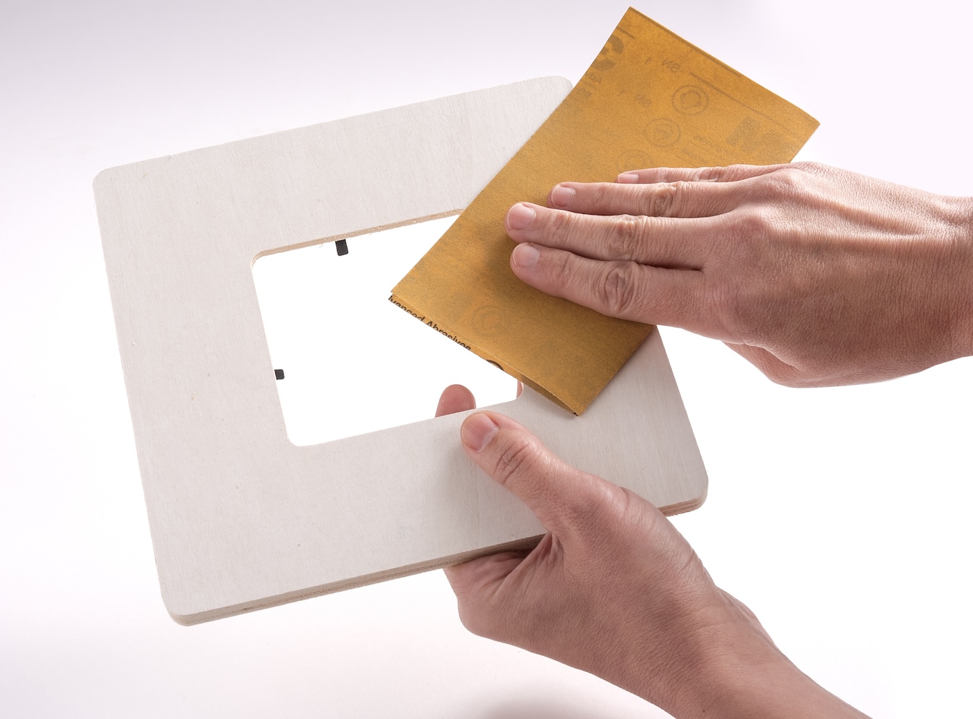 Sanding a wood frame with sandpaper