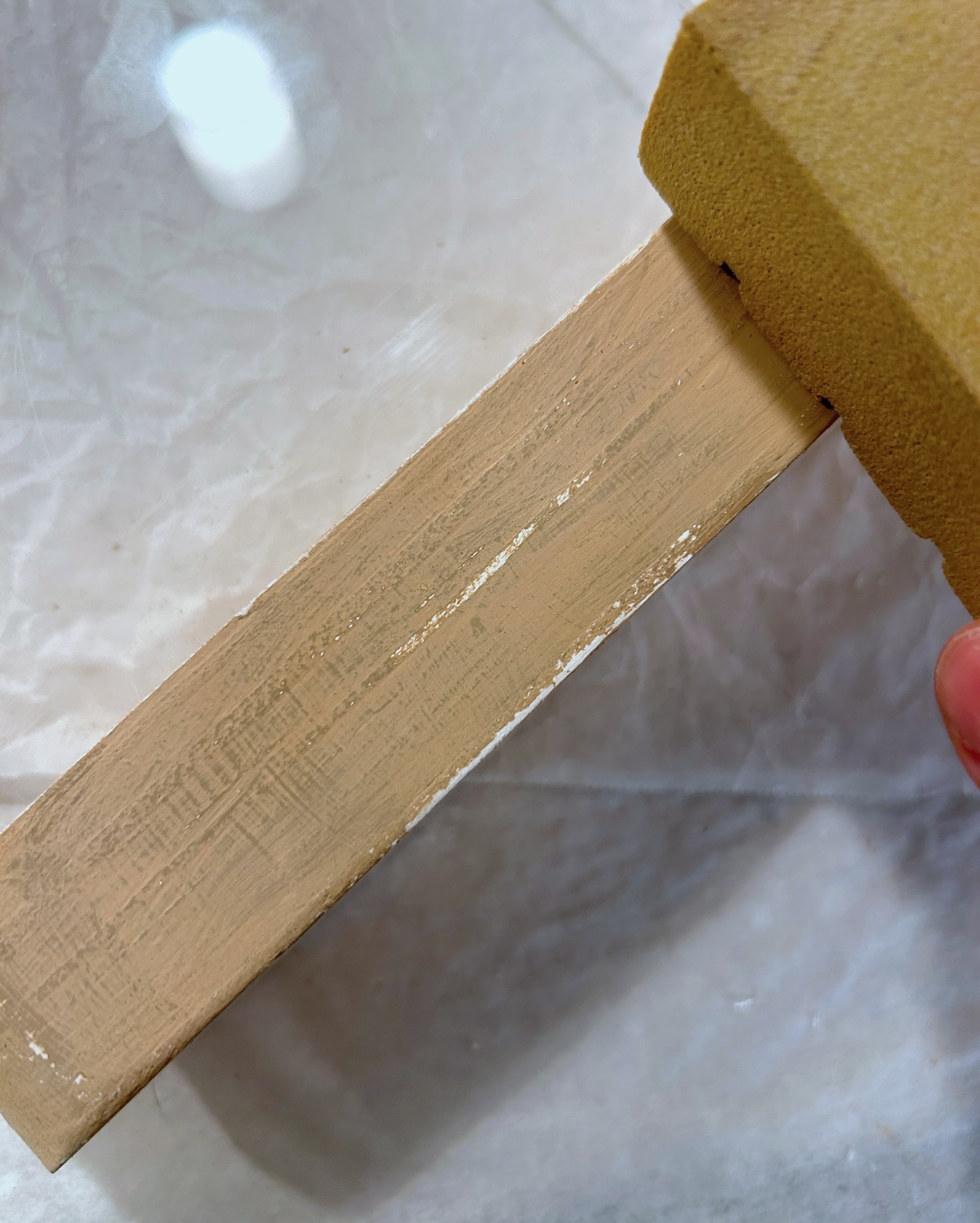 Sanding off the khaki paint to cause distressing