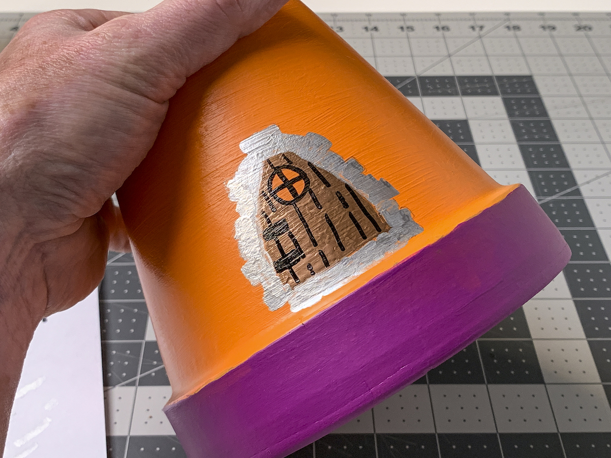 Silver stone accents on a fairy door design on a clay pot