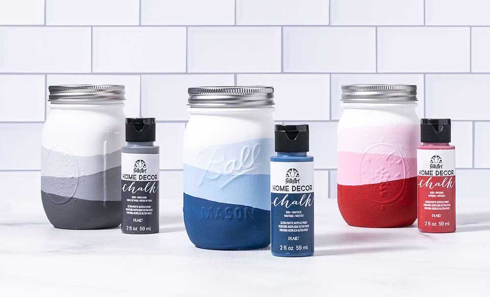 Three mason jars painted gray blue and red