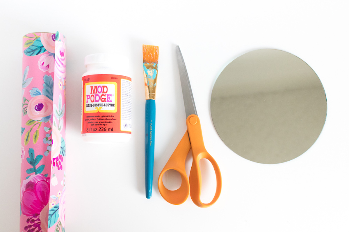 Wrapping paper, Mod Podge, paintbrush, scissors, and a mirror